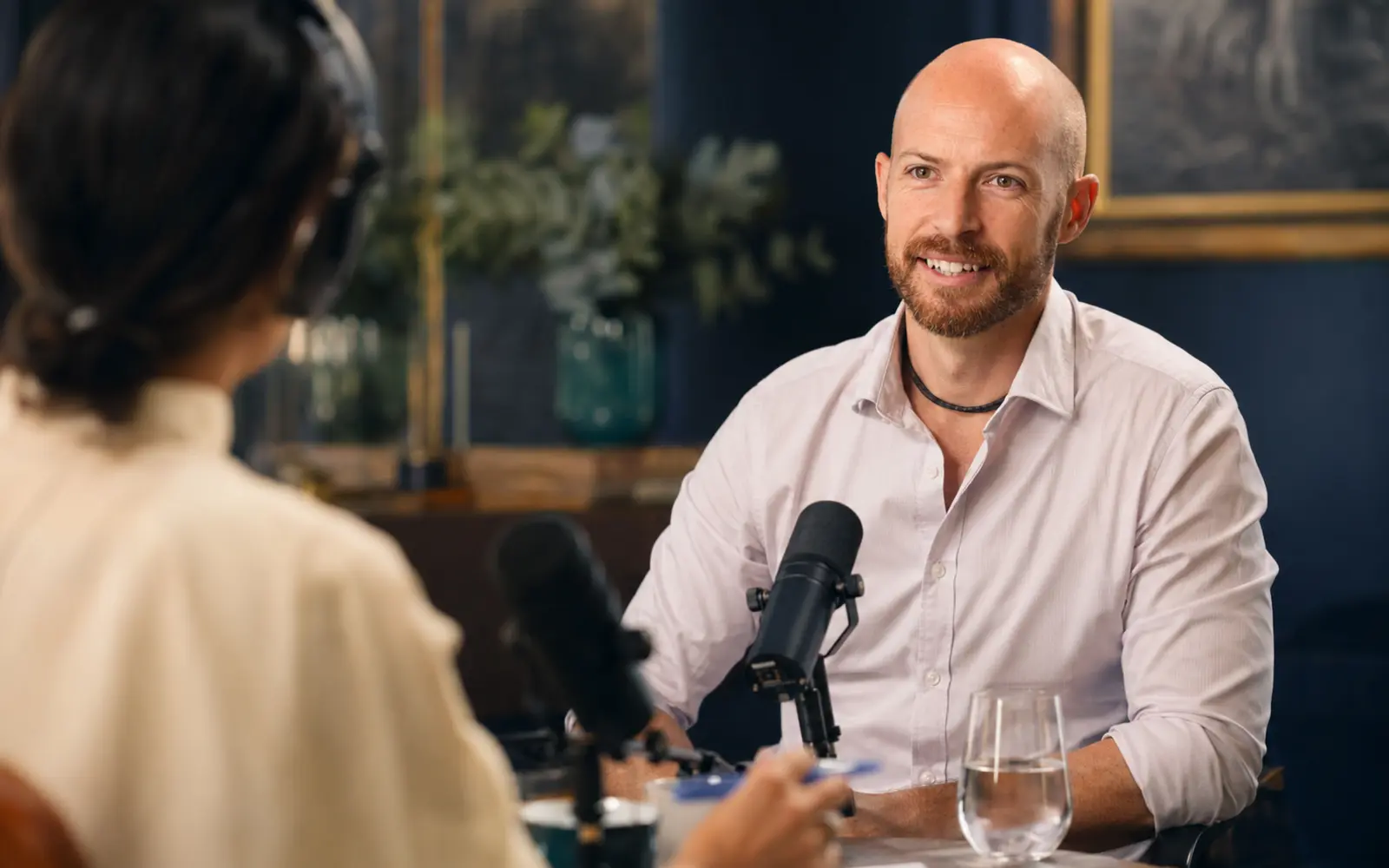 An intimate, beautifully designed recording conversation with real attentive listening, subtle studio equipment and lived-in warmth.