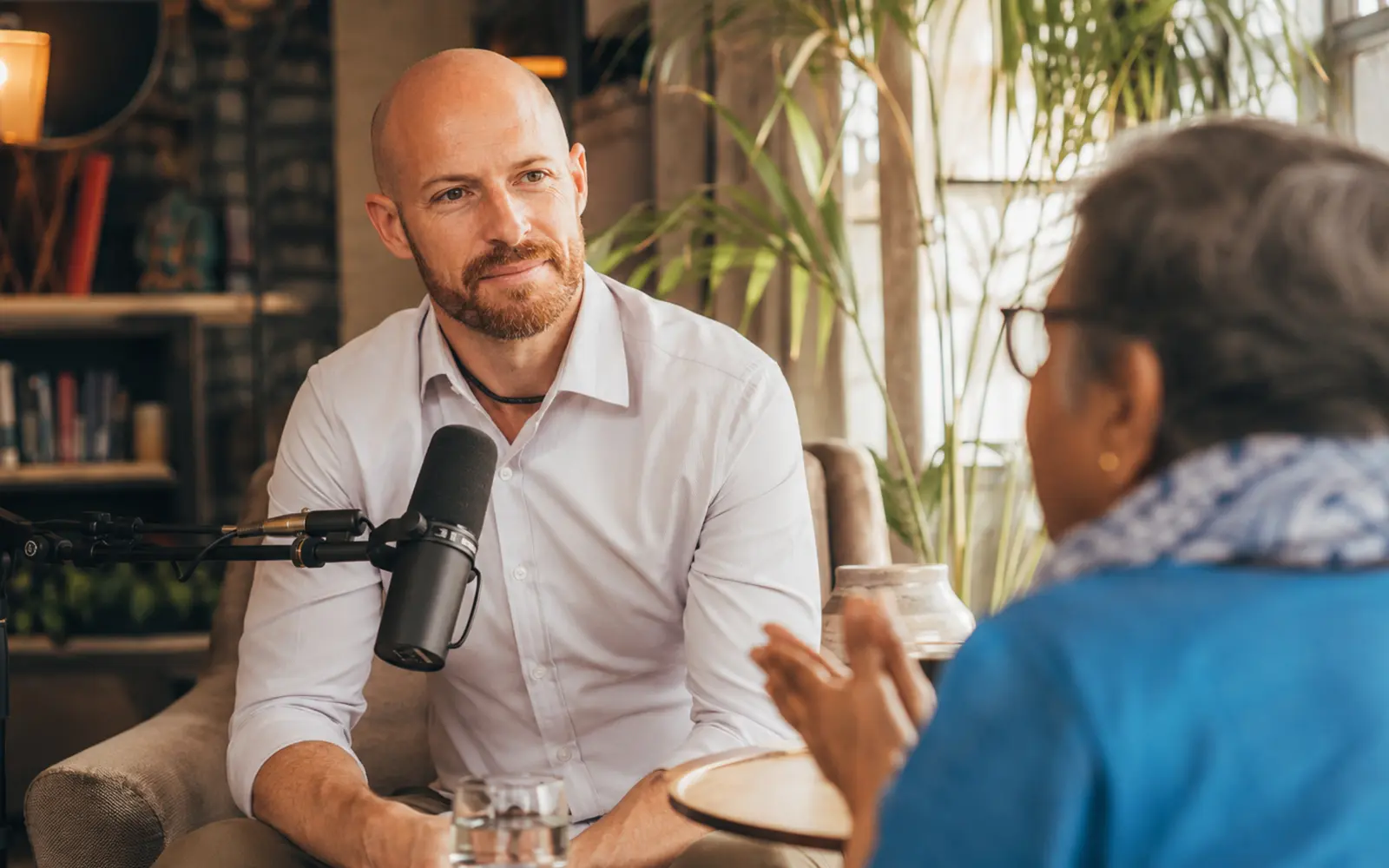 An intimate, beautifully designed recording conversation with real attentive listening, subtle studio equipment and lived-in warmth.